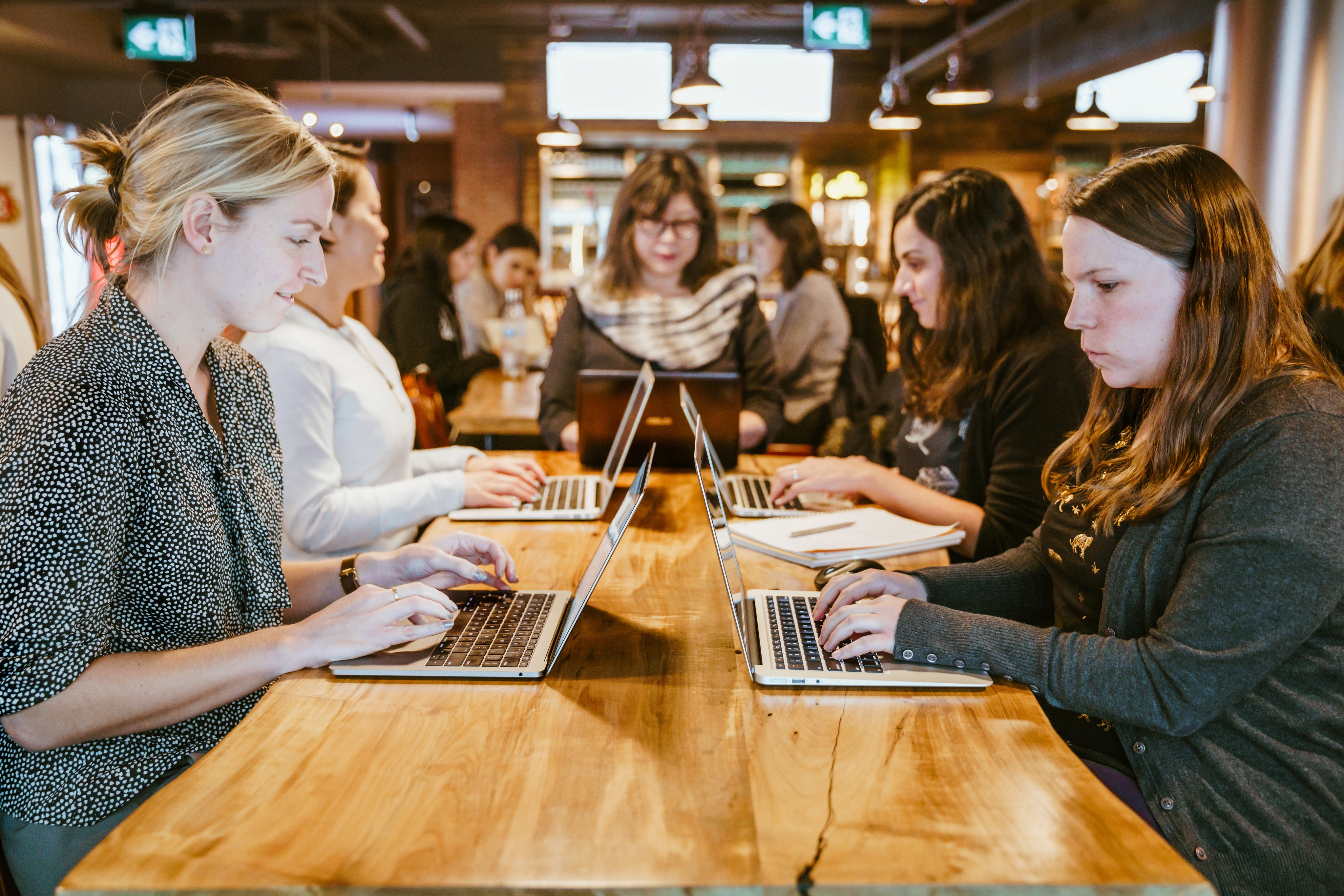 Donne che utilizzano dei computer portatili su un tavolo di legno